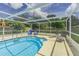 Inviting screened in pool area with lounge chairs, pool toys and beautiful blue water at 1829 1St E Ave, Bradenton, FL 34208
