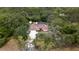 Overhead view showcases the home with a screened pool and shed amidst a lush, wooded landscape at 18546 Kelly Rd, Spring Hill, FL 34610