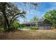Lush backyard with mature trees, tropical plants, and screened-in pool providing a private oasis at 18546 Kelly Rd, Spring Hill, FL 34610