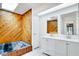 Modern bathroom featuring wood accent wall, skylight, dual sinks, and a bathtub at 18546 Kelly Rd, Spring Hill, FL 34610