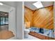 Stylish bathroom featuring a bathtub with wooden walls, skylight, and tiled floor at 18546 Kelly Rd, Spring Hill, FL 34610