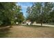 Well-manicured front yard featuring a long driveway and mature trees, creating a welcoming entrance at 18546 Kelly Rd, Spring Hill, FL 34610