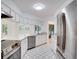 Well lit kitchen featuring stainless steel appliances, stone countertops and white cabinetry at 18546 Kelly Rd, Spring Hill, FL 34610