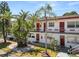 Charming condo featuring red entry doors, tropical landscaping, and well-maintained grounds at 1900 58Th N Ave # 26, St Petersburg, FL 33714