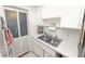 Efficient kitchen features a double sink, white cabinetry, and door to the outside at 1900 58Th N Ave # 26, St Petersburg, FL 33714