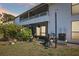 Backyard patio with grill, manicured lawn, decorative lights, and building with screened balcony at 1981 Lakewood Club S Dr # 4M, St Petersburg, FL 33712