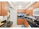 Functional kitchen with stainless steel appliances, granite counters, tile floors, and a view into the living area at 1981 Lakewood Club S Dr # 4M, St Petersburg, FL 33712