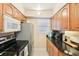Well-lit kitchen featuring stainless steel appliances, ample counter space, wood cabinets, and a neutral color scheme at 1981 Lakewood Club S Dr # 4M, St Petersburg, FL 33712