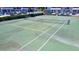 Outdoor tennis court with green surface, white boundary lines, yellow game lines, and black net at 1981 Lakewood Club S Dr # 4M, St Petersburg, FL 33712
