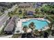 Community pool with lounge chairs and umbrellas surrounded by palm trees and lush landscaping at 1984 Hawks View Dr, Ruskin, FL 33570