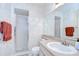 Cozy bathroom featuring wallpaper with floral designs, a glass shower, and a mirror above the single sink vanity at 2117 Laindale Pl, Valrico, FL 33596