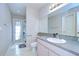Bright bathroom with a large mirror, a single sink vanity, and a shower with a blue patterned curtain at 2117 Laindale Pl, Valrico, FL 33596