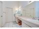 Bathroom with double vanity sinks, tile floors, and decorative pastel wallpaper at 2117 Laindale Pl, Valrico, FL 33596