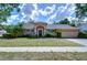 Charming single-story home featuring a stucco exterior, arched windows, and a well-maintained front yard at 2117 Laindale Pl, Valrico, FL 33596