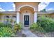 Inviting front entrance with elegant columns, arched windows, and manicured landscaping at 2117 Laindale Pl, Valrico, FL 33596