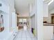 Hallway featuring white tile flooring, built-in storage, and a view into the living room and kitchen areas at 2117 Laindale Pl, Valrico, FL 33596