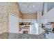 Bright kitchen with white appliances, granite countertops, island, and decorative wallpaper at 2117 Laindale Pl, Valrico, FL 33596