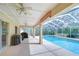 Covered pool area featuring a swimming pool, a hot tub, ceiling fans, and two grills overlooking the backyard at 2117 Laindale Pl, Valrico, FL 33596