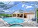 Covered pool area featuring a swimming pool, a hot tub, ceiling fans, and two grills overlooking the backyard at 2117 Laindale Pl, Valrico, FL 33596