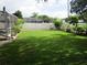 Lush backyard features a green lawn, mature landscaping, and a white fence for privacy at 2213 Towering Oaks Cir, Seffner, FL 33584