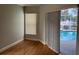 Bedroom with wood floors and sliding glass doors leading to a screened-in pool area at 2213 Towering Oaks Cir, Seffner, FL 33584