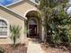 Inviting home entrance with manicured landscaping and arched doorway at 2213 Towering Oaks Cir, Seffner, FL 33584