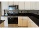 Well-equipped kitchen with stainless steel appliances and dark countertops at 2213 Towering Oaks Cir, Seffner, FL 33584