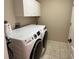 Laundry room equipped with a modern washer and dryer set and overhead cabinets at 2213 Towering Oaks Cir, Seffner, FL 33584