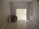 Bright living room with tiled floor, featuring an armchair and sliding glass door at 2213 Towering Oaks Cir, Seffner, FL 33584