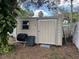 Storage shed has a window and a large door, adjacent to a white picket fence at 2213 Towering Oaks Cir, Seffner, FL 33584