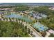 A scenic aerial view featuring a lake, community pool, tennis courts and basketball court at 29895 Picana Ln, Wesley Chapel, FL 33543