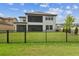 A spacious backyard featuring green grass and a black metal fence at 29895 Picana Ln, Wesley Chapel, FL 33543