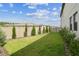 A beautiful backyard with green grass, a fence lined with trees, and a sunny sky at 29895 Picana Ln, Wesley Chapel, FL 33543