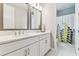 Bright bathroom featuring double vanity with modern fixtures and a shower with decorative curtain at 29895 Picana Ln, Wesley Chapel, FL 33543