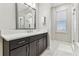 Bathroom featuring dark cabinets, marble countertops, and a large mirror, creating a sleek design at 29895 Picana Ln, Wesley Chapel, FL 33543