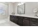 Bathroom vanity area with dark wood cabinets, light countertops, decorative mirror and great lighting at 29895 Picana Ln, Wesley Chapel, FL 33543