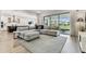 Stylish living room with large windows and an open layout to the modern kitchen at 29895 Picana Ln, Wesley Chapel, FL 33543