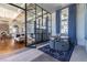 A stylish lounge area featuring modern furniture, a large glass wall, and elegant lighting at 29895 Picana Ln, Wesley Chapel, FL 33543
