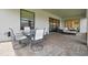 Covered patio area with a table and chairs, offering an outdoor dining space with a view of the backyard at 29895 Picana Ln, Wesley Chapel, FL 33543