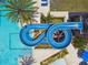 Aerial view of a blue water slide winding around a sparkling pool with sun loungers at 29895 Picana Ln, Wesley Chapel, FL 33543