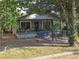 Lovely bungalow with charming front porch and secured with a chain-link fence, nestled among mature trees at 3503 N 11Th St, Tampa, FL 33605