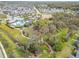 Aerial view showcasing the community amenities, walking paths, pool, and recreational areas amidst a backdrop of lush greenery at 3603 Woodmont Dr, Parrish, FL 34219