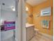 Charming bathroom adjacent to bedroom featuring vanity with mirror, and stylish orange walls at 3603 Woodmont Dr, Parrish, FL 34219