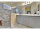 Bright bathroom with double vanity, framed mirror, and walk-in shower at 3603 Woodmont Dr, Parrish, FL 34219