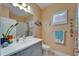 Well-lit bathroom features vanity with sink, decorative accents, and tiled shower at 3603 Woodmont Dr, Parrish, FL 34219