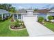 Charming single-Gathering home featuring a well-manicured lawn, landscaped garden beds, and a two-car garage at 3603 Woodmont Dr, Parrish, FL 34219
