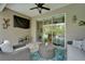 Outdoor seating area on lanai with ceiling fan, TV, and access to interior and pool at 3603 Woodmont Dr, Parrish, FL 34219