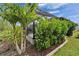 Lush landscaping featuring manicured shrubs and palm trees surrounding the screened-in patio area at 3603 Woodmont Dr, Parrish, FL 34219