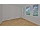 Bright bedroom showcasing hardwood floors, white walls, baseboards and three windows offering ample natural light at 3614 W Platt St, Tampa, FL 33609