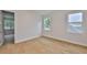 Bright bedroom with hardwood floors and natural light from two windows, with an open doorway to another room at 3614 W Platt St, Tampa, FL 33609